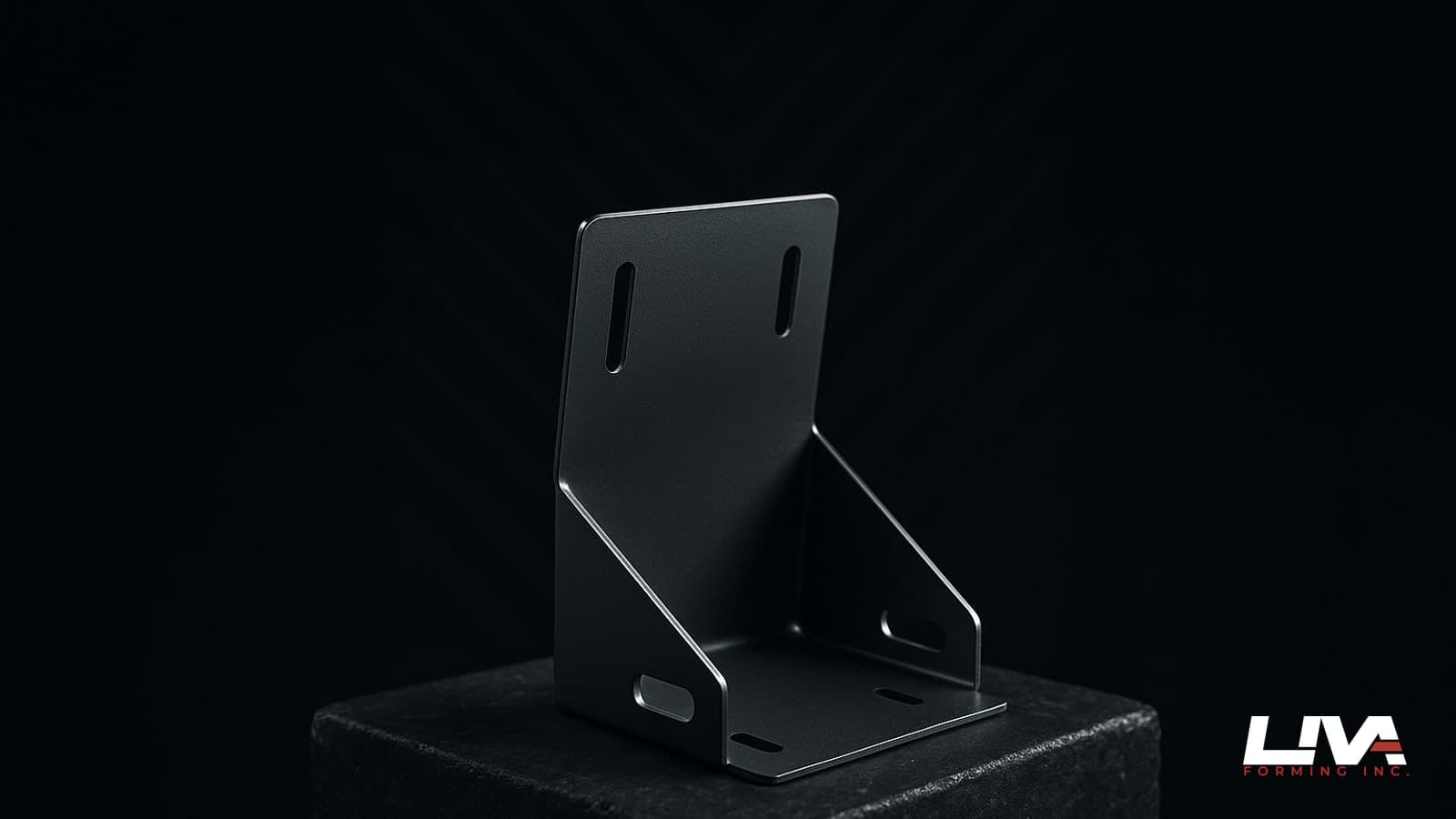 Matte graphite CNC-cut and folded steel bracket with crisp slots standing on dark stone under rim light