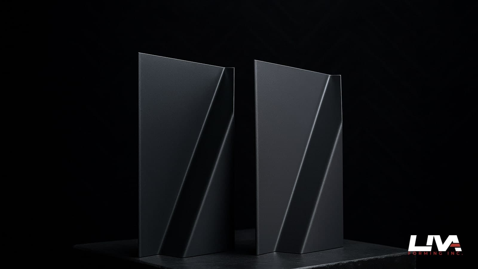 Two matte graphite and charcoal metal flashing samples under raking studio light