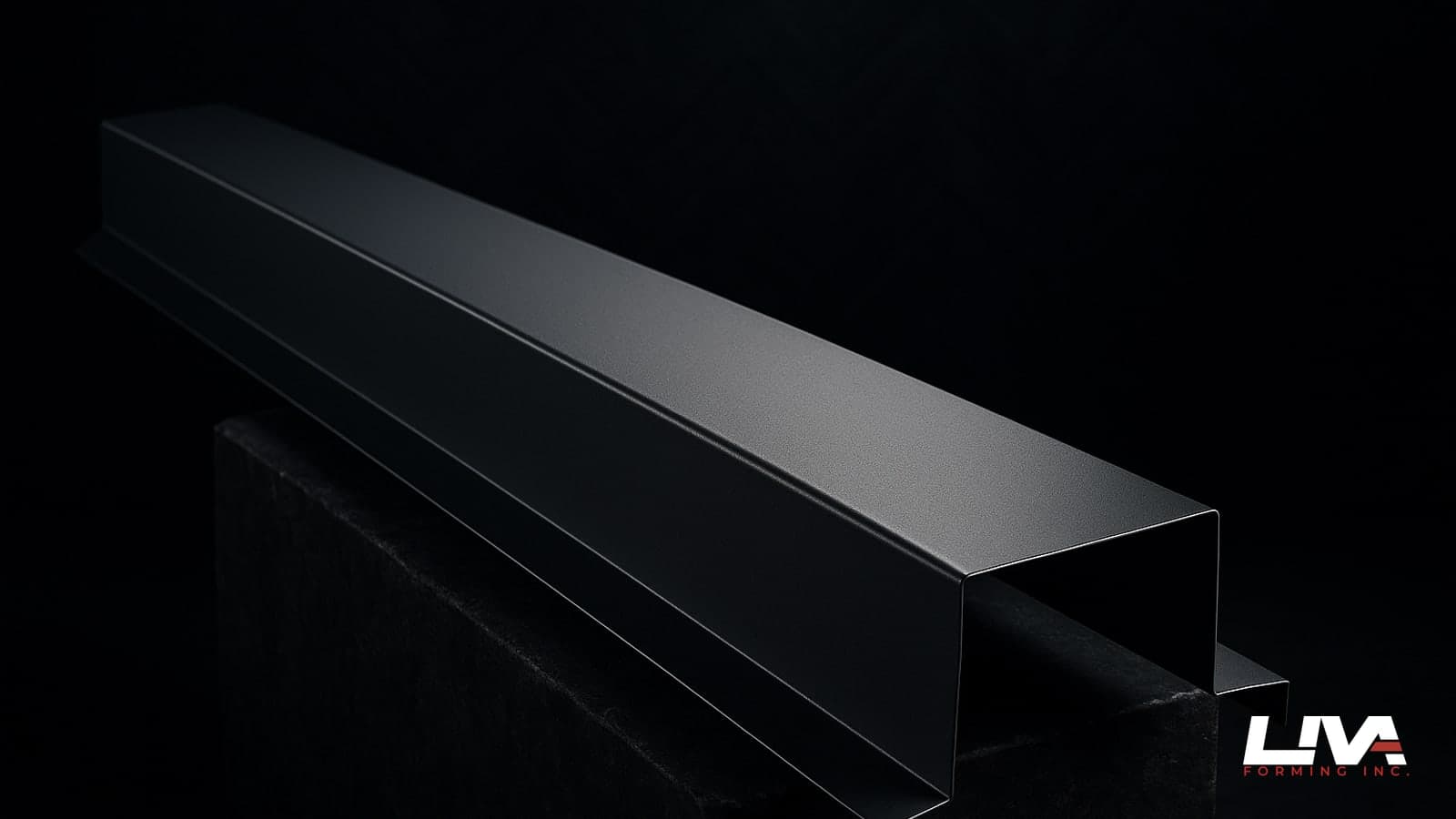 Matte graphite parapet cap with sloped top and hemmed drip edges on a stone plinth